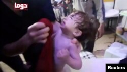 FILE - A child cries as its face is wiped following an alleged chemical weapons attack in Douma, Syria, in this still image from video obtained by Reuters, April 8, 2018.