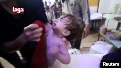 A child cries following an alleged chemical weapons attack, in what is said to be Douma, Syria, in this still image from video obtained by Reuters, April 8, 2018.