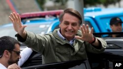 FILE - Jair Bolsonaro waves after voting in the presidential runoff election in Rio de Janeiro, Brazil, Oct. 28, 2018. 