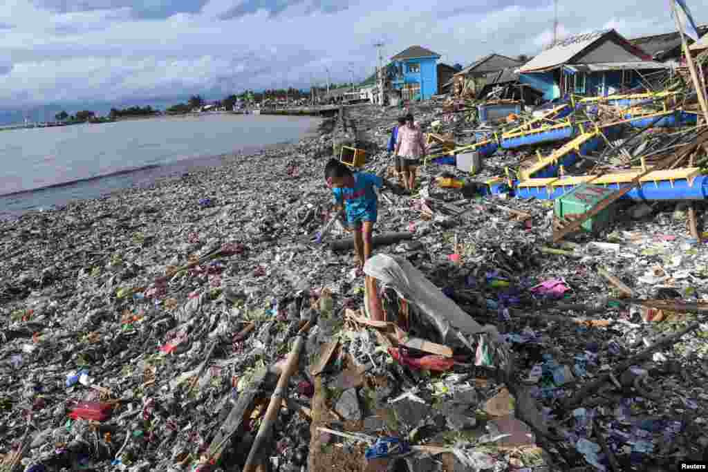 Residents walk among debris after the tsunami at Labuan in Pandeglang, Banten province, Indonesia, Dec. 26, 2018, in this photo taken by Antara Foto.