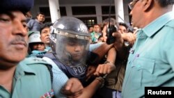 Anggota kepolisian mengawal Mohammed Sohel Rana, pemilik Rana Plaza yang ambruk minggu lalu, seusai menjalani pemeriksaan di Pengadilan Tinggi di Dhaka, Bangladesh (30/4).