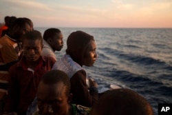 Sub-Saharan migrants stand on the deck of the Golfo Azzurro rescue vessel as they arrive at the port of Pozzallo, Italy, June 17, 2017.