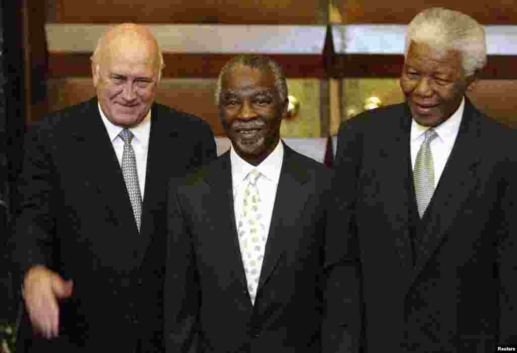 Tous anciens président de l&#39;Afrique du Sud, Thabo Mbeki, le successeur de Mandela (au centre) et FW de Klerk, le prédecesseur de Mandela (à gauche) et Nelson Mandela (à droite) posent pour les photographes au Parlement au Cap. Photo d&#39;archive prise après l&#39;élection de Mbeki en tant que président de l&#39;ANC le 10 mai 2004. 