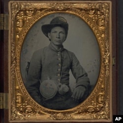 Unidentified young soldier in Confederate shell jacket, Hardee hat with Mounted Rifles insignia between 1861 and 1865.