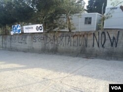 Graffiti outside the refugee camp, now essentially a detention center, in Lesbos, Greece, April 1, 2016. (H. Murdock/VOA)