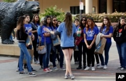 FILE - In this Feb. 26, 2015, file photo, a UCLA campus tour guide leads prospective college-bound high school seniors on a campus tour in Los Angeles.