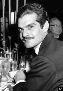 FILE - Actor Omar Sharif poses for a photo at a dinner party following the movie premiere of "Lawrence of Arabia" in Hollywood, California, Dec. 21, 1962.