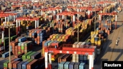 2013年12月10日堆放在山东省青岛港口的海运集装箱。星期二中国领导人闭门讨论2014年经济和改革计划。数据显示中国经济的年中回升持续到了最后一个季度。