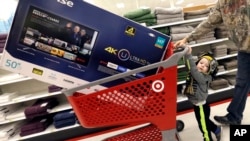 FILE - Hunter Harvey and his dad, C.J., plan to purchase a big screen TV at Target, in Wilmington, Massachusetts, Nov. 25, 2016. The U.S. Commerce Department reported Tuesday, Nov. 29, 2016, that the economy grew faster than expected between July and September due to strong consumer spending. 