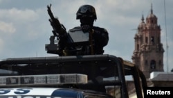 FILE - A Federal police patrol mans a weapon atop a vehicle in Morelia, in the Mexican state of Michoacan Oct. 28, 2013. Mexico stepped up security in the troubled western region after a string of attacks on electricity installations temporarily knocked out power for hundreds of thousands of people.