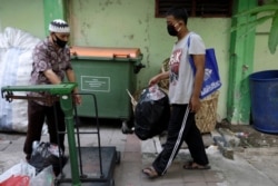 Seorang siswa yang memakai masker membawa sekantong botol plastik untuk ditukar dengan akses internet wifi gratis untuk belajar online, Jakarta, 9 September 2020. (Foto: REUTERS/Willy Kurniawan)