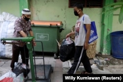 Seorang siswa yang memakai masker membawa sekantong botol plastik untuk ditukar dengan akses internet wifi gratis untuk belajar online, Jakarta, 9 September 2020. (Foto: REUTERS/Willy Kurniawan)