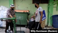 Seorang siswa yang memakai masker membawa sekantong botol plastik untuk ditukar dengan akses internet wifi gratis untuk belajar online, Jakarta, 9 September 2020. (Foto: REUTERS/Willy Kurniawan)