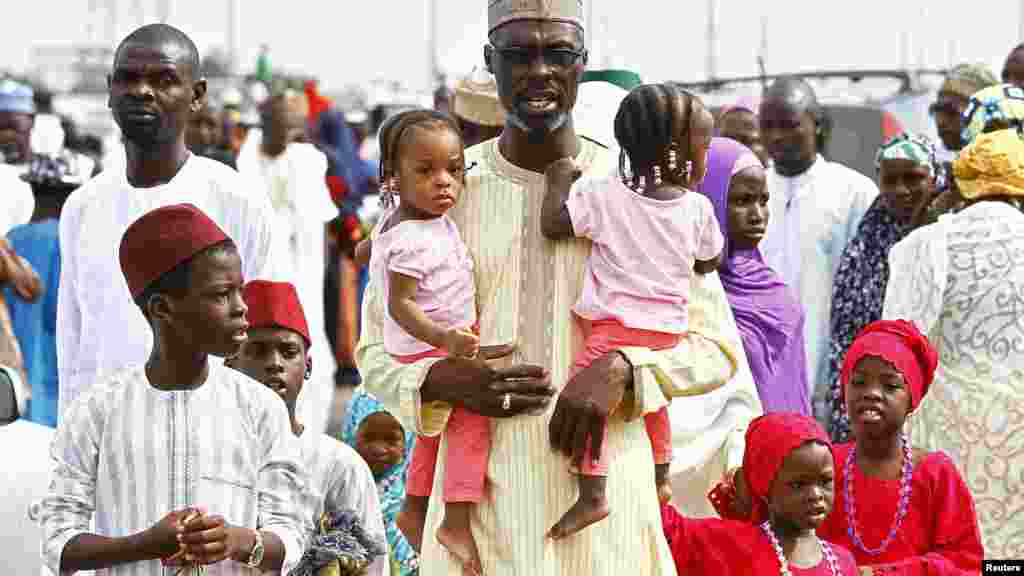 A man and his family walk after prayers during Sallah festival in Abuja, October 15, 2013.