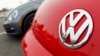 FILE - The Volkswagen logo on the hood of a 2012 Beetle at a Volkswagen dealership. Investigators seized computer hard drives and documents from VW's headquarters in Seoul and from the home of at least one senior manager.