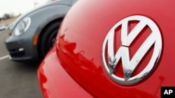 FILE - The Volkswagen logo on the hood of a 2012 Beetle at a Volkswagen dealership. Investigators seized computer hard drives and documents from VW's headquarters in Seoul and from the home of at least one senior manager.