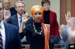 FILE - In this Jan. 3, 2017 photo, State Rep. Ilhan Omar takes the oath of office as the 2017 Legislature convened in St. Paul, Minn. Omar is the nation's first Somali-American to be elected to a state legislature.