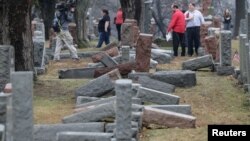 FILE - Local and national media report on more than 170 toppled Jewish headstones after a weekend vandalism attack on Chesed Shel Emeth Cemetery in University City, a suburb of St Louis, Missouri, Feb. 21, 2017. 