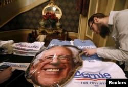 FILE - A vendor looks for a t-shirt size at a U.S. Democratic presidential candidate Bernie Sanders' campaign event in Sioux City, Iowa, United States, Jan. 19, 2016.