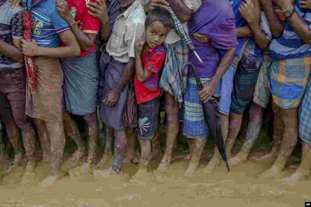 انتظار پسر بچه آواره روهینگیایی در یک صف طولانی برای دریافت غذا که در کمپ پناهندگان در بنگلادش توزیع می شود.