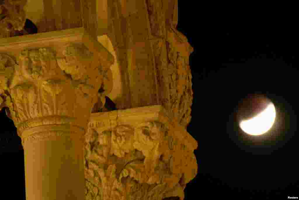 اٹلی کی تاریخی عمارت کی اوٹ سے نظر آتا چاند۔ یہ منظر گرہن کے وقت کیمرے کی آنکھ میں محفوظ کر لیا گیا۔