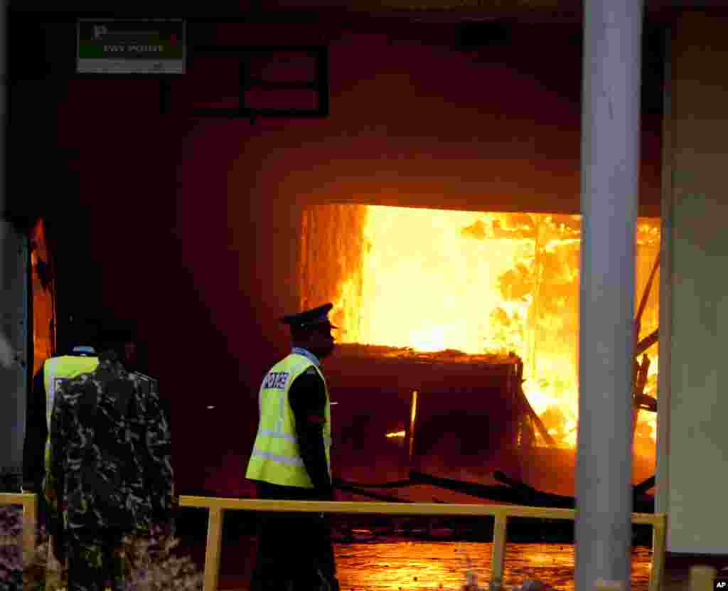 Police look at the fire near the international arrivals area of Jomo Kenyatta International Airport, Nairobi, August 7, 2013.