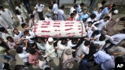 Family members carry the casket of Waja Ahmad Karim Dad, 60, who was killed during a shootout by unidentified men a day earlier, for his burial in Karachi August 18, 2011.