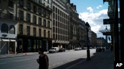 Un homme marche dans une rue vide pendant le confinement national destiné à contrer le Covid-19, à Paris, samedi 18 avril 2020. (AP Photo / Thibault Camus)