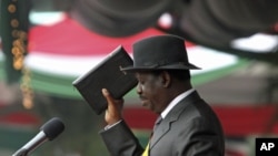 Kenya's Prime Minister Raila Odinga reads the oath of office during the promulgation of the New Constitution at Uhuru Park in Nairobi, Aug 27, 2010