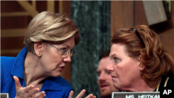 La senadora Elizabeth Warren conversa con su colega Heidi Heitkamp durante una audiencia en el Senado, en enero del 2018.