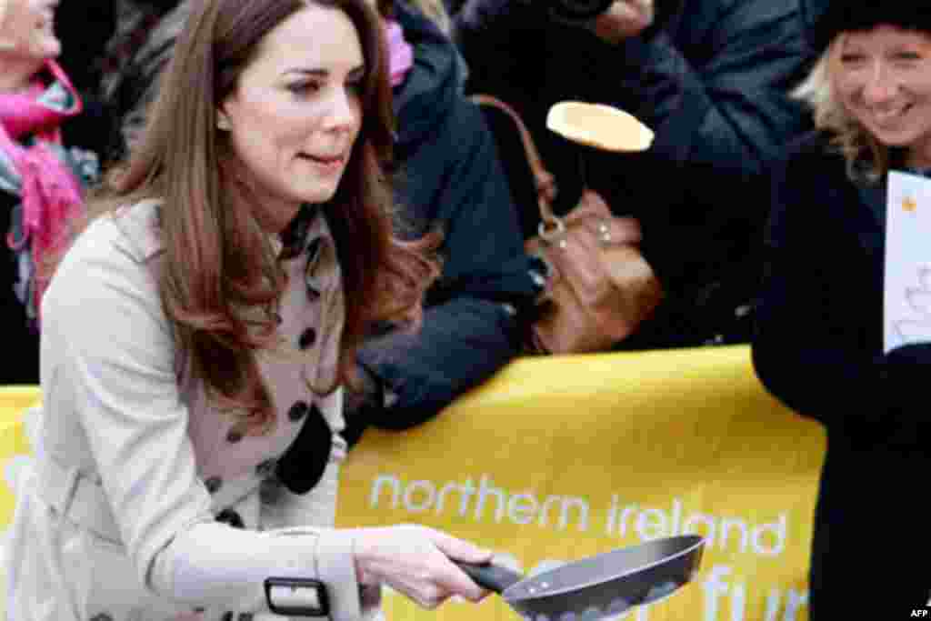 Kate Middleton flips a pancake at a display by the charity Northern Ireland Cancer Fund for Children, outside the City Hall in Belfast, Northern Ireland, Tuesday March 8, 2011.