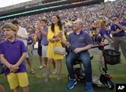 El jefe de la mayoría republicana en la Cámara de Representantes, Steve Scalice, de Luisiana, acompañado de su esposa Jennifer, recibe un homenaje durante un juego de fútbol americano entre la Universidad de Luisiana y el equipo de Troy en Baton Rouge. Sept.30, 2017.