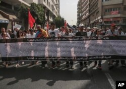 Demonstrators carry a banner with the names of detained activists during a protest in Casablanca, Morocco, Oct. 8, 2017.