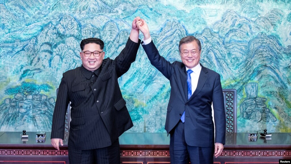Tổng thống Hàn Quốc Moon Jae-in và lãnh tụ Triều Tiên Kim Jong Un nắm tay nhau đưa lên cao sau khi ký Tuyên bố chung Thượng đỉnh liên Triều ngày 27/4/2018 tại Bản Môn Ðiếm ở khu phi quân sự chia cắt hai miền Nam-Bắc Triều Tiên.