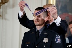 President Donald Trump presents the Medal of Valor to Alexander Jensen of the Alexandria, Virginia Police Department during a ceremony in the East Room of the White House in Washington, July 27, 2017.