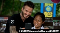 David Beckham, duta Besar Goodwill UNICEF dan mantan atlet sepak bola internasional, mengambil selfie bersama Sripun (15) di SMPN 17 Semarang.