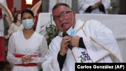 Sergio Valverde Espinoza, a Catholic priest of the Cristo Rey church who modified a popular song called "Sopa de Caracol," or Snail Soup in English, gestures during a Mass in San Jose, Costa Rica, Sunday, May 2, 2021.