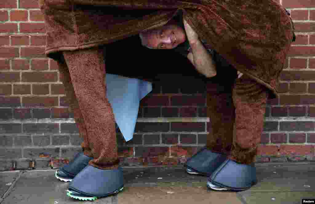 A participant peeks from his costume before the start of the the annual London Pantomime Horse Race in Greenwich, Britain.