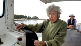 Virginia Oliver, age 101, pilots her son Max Oliver's boat, Tuesday, Aug. 31, 2021, off Rockland, Maine. (AP Photo/Robert F. Bukaty)