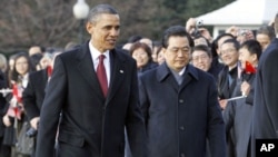 U.S. President Barack Obama and Chinese President Hu Jintao walk past guests during an official South Lawn arrival ceremony for Hu at the White House in Washington, 19 Jan 2011