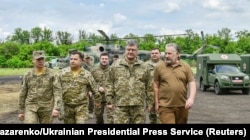 Ukrainian President Petro Poroshenko, second from right, in the front, meets with servicemen at a military mobile hospital during his visit to Donetsk region, Ukraine, June 14, 2017.