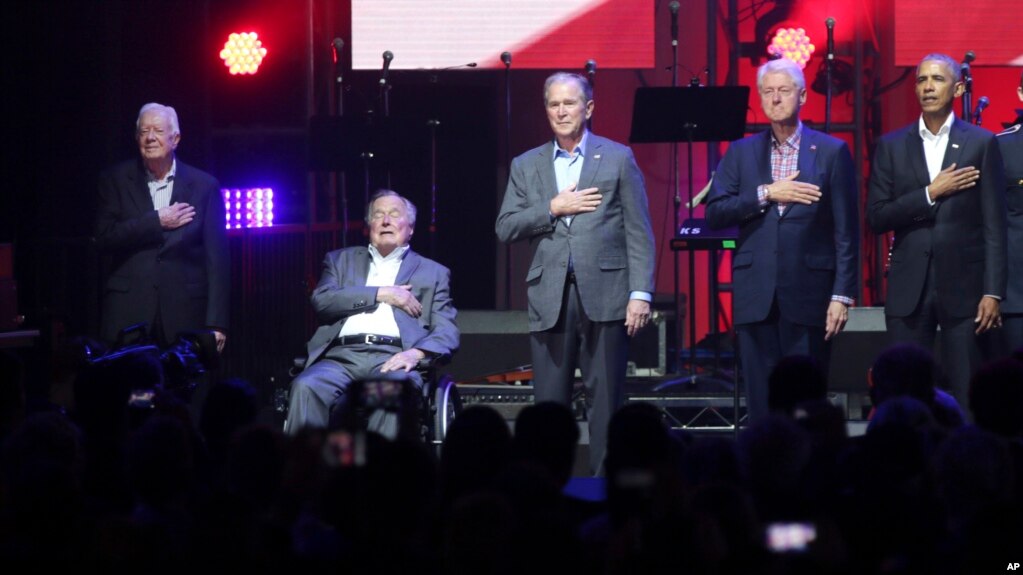 在德克萨斯州为数场飓风灾民举办的演唱会上，从右至左，美国前总统奥巴马、克林顿、小布什、老布什和卡特把手按在心口处聆听国歌的演奏。（2017年10月21日）