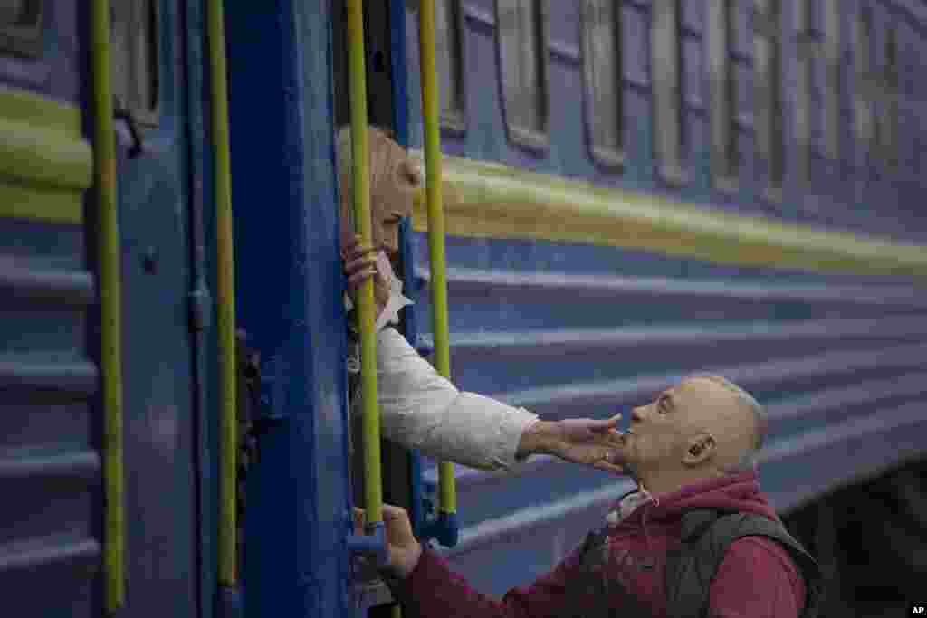A woman bids a man goodbye after boarding a Lviv-bound train, in Kyiv, Ukraine.