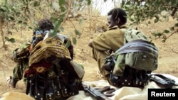 FILE - Members of an Oromo rebel group chat under a tree at their training camp in Ethiopia. Peace talks between Ethiopia's federal government and the rebel Oromo Liberation Army began April 25, 2023, and have raised hopes of ending years of violence between the two sides.