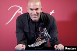 Mantan pemain sepak bola Prancis berpose dengan "Zidane's Crystal Foot" yang dibuat oleh Baccarat di Paris, Prancis, 12 Juni 2018. (Foto: REUTERS/Benoit Tessier)