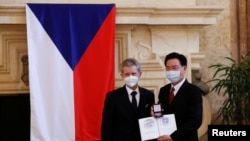 2021年10月7日，捷克参议院议长米洛斯·维斯特西尔在布拉格向台湾外交部长吴钊燮颁发捷克共和国议会参议院银质纪念章。（路透社）