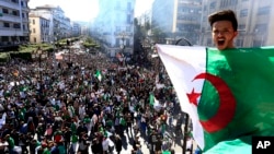A protester shouts as he holds the national flag during a demonstration in Algiers, Algeria, March 15, 2019.