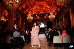 A plus-size model presents a dress at a fashion show as part of a day against fat phobia in Paris, Dec. 15, 2017.