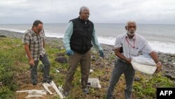 Các chuyên gia Malaysia tìm kiếm các mảnh vỡ của chiếc máy bay Malaysia MH370 trên bãi biển ở đảo Reunion, ngày 4/8/2015.