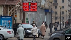Una pantalla muestra las tasas de cambio del rublo en una calle del centro de Moscú. Las expectativas economómicas para el próximo año no lucen bien.